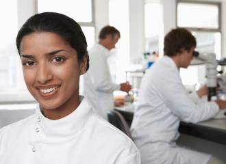 Happy Female Scientist In Laboratory